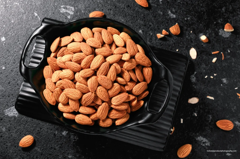 Almonds in a black bowl – product photography by Shreeji, Nagpur